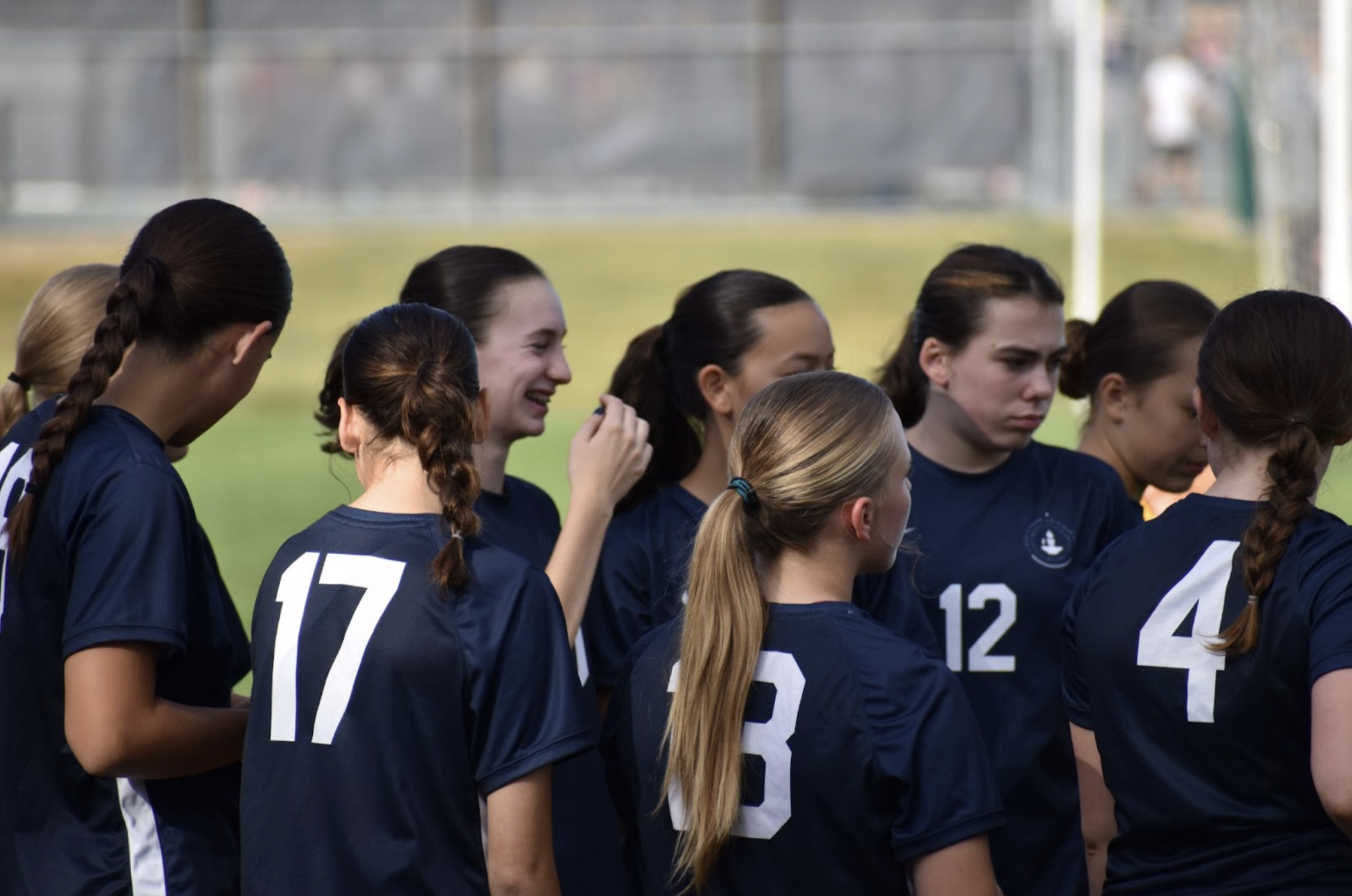 WIN. The Girls Varsity Soccer team joins each other in a huddle a couple minutes before the game begins.
